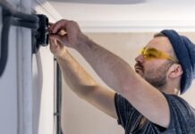 Enhancing Your Home with Electrical Upgrades An Electrician is Mounting Electric Sockets on The White Wall Indoors