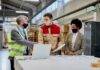 A Guide to Conducting Workplace PPE Hazard Assessments Woodworking Company Managers Communicating With Male Worker at production facility.
