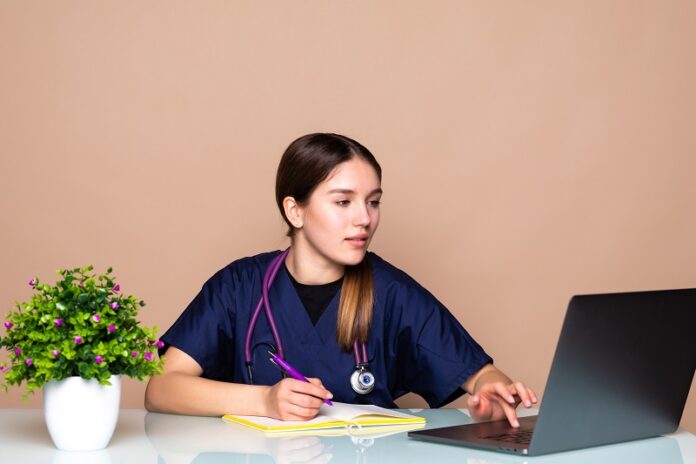 Shot of female doctor talking with colleagues through a video call with a laptop in the consultation.